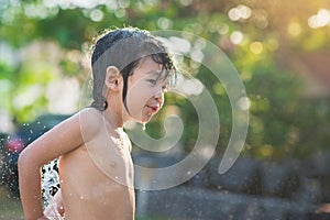 Cute asian boy has fun playing in water