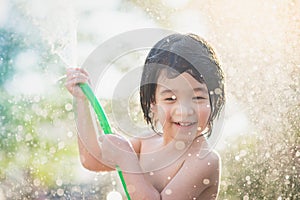 Cute asian boy has fun playing in water