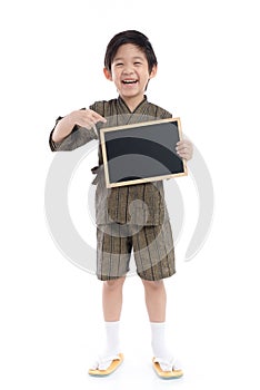 Cute asian boy in kimono holding black board