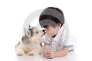 Cute asian boy and siberian husky puppy lying