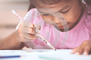 Cute asian child girl having fun to draw and paint