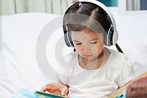 Cute asian child girl in headphones listening the music