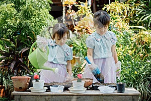 Cute asian child girl helping mother planting or cutivate the plants. Mom and daughter engaging in gardening at home. Happy activi