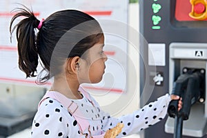 Cute Asian child girl holding an ev car electric charger