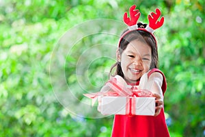 Cute asian child girl holding and giving Christmas gift