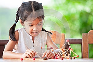 Cute asian child girl playing and creating with play dough