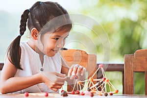 Cute asian child girl playing and creating with play dough