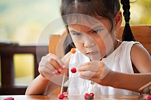 Cute asian child girl playing and creating with play dough