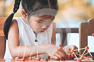 Cute asian child girl playing and creating with play dough