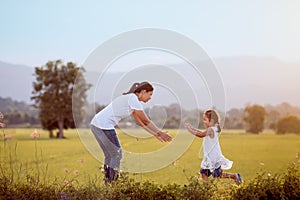 Cute asian child girl running to her mother to give a hug