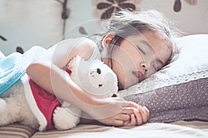 Cute asian child girl sleeping and hugging her teddy bear