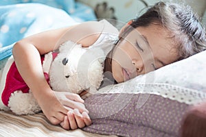 Cute asian child girl sleeping and hugging her teddy bear