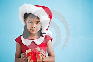 Cute asian child girl wearing santa hat and holding gift box