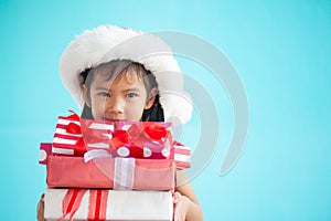 Cute asian child girl wearing santa hat and holding gift box