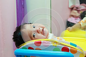 Cute Asian children happiness in a colorful stroller in the  room