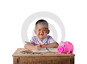 Cute asian country boy Make a note of income receipts and coins with piggy bank isolated on white background