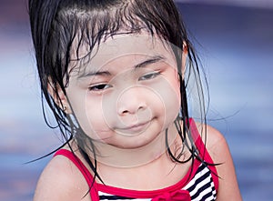 Cute asian female toddler child while playing on water in a swimming pool