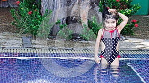 Cute asian female toddler child while swimming and playing on a swimming pool
