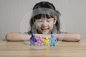 Cute asian girl Build a plasticine figure of mom, dad and child and sibling.