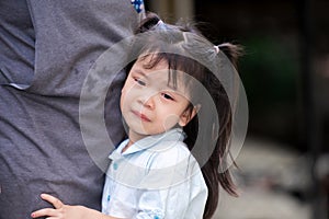 Cute Asian girl is crying. Child stands and hugs her mother. Children was sad, tears flowed down his cheeks. Kid is 4 years old