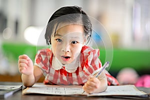 Cute Asian girl doing her homework.