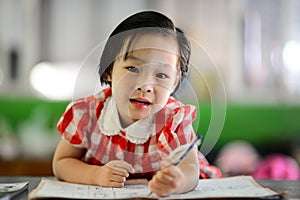 Cute Asian girl doing her homework.