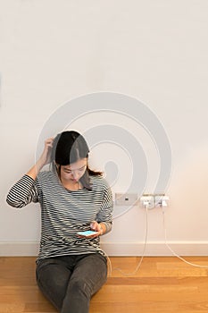 Cute asian girl frustrating with phone, charging battery, with copy space photo