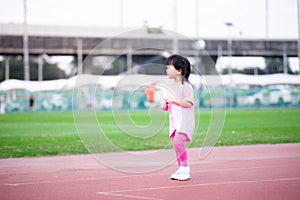 Cute Asian girl jogging exercise in the stadium. Active child sweet smile. Happy children good health, play sports.