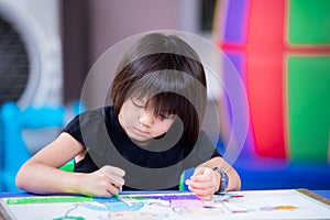 Cute Asian girl is making art drawing and painting a story about herself and her sister on paper.