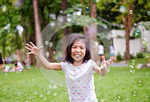 A cute girl playing with bubbles, laughing and smiling