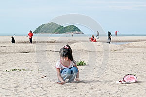 Cute Asian girl playing with sand