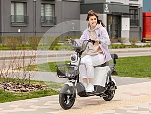 cute asian girl rides electric scooter in modern city photo