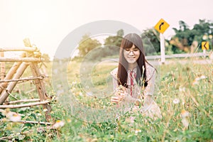 Cute asian girl smile at meadow grass flower field