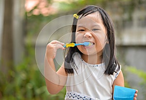 Cute Asian kid brushing teeth photo