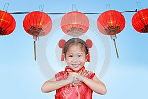 Cute asian kid girl in Traditional Chinese dress against aligned Chinese Red Lanterns, Chinese new year concept