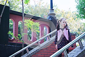 Cute Asian little beautiful girl play at autumn in the city park