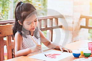 Cute asian little child girl drawing and painted a heart