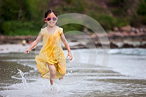 Cute asian little child girl having fun to play and run on beach