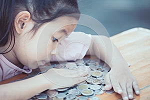 Cute asian little child girl hugging and stingy her money