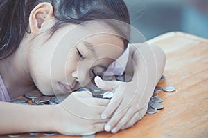 Cute asian little child girl hugging and stingy her money photo