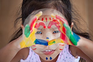 Cute asian little child girl with painted hands make heart shape