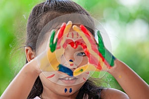 Cute asian little child girl with painted hands make heart shape