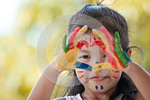 Cute asian little child girl with painted hands make heart shape