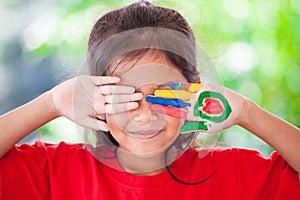 Asian little child girl with painted hands smiling with fun and happiness