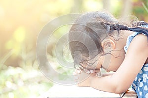 Cute asian little child girl praying with folded her hand