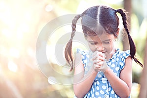 Cute asian little child girl praying with folded her hand