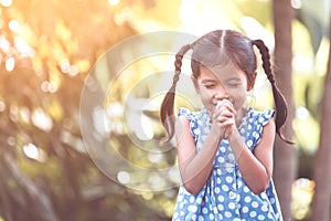 Cute asian little child girl praying with folded her hand