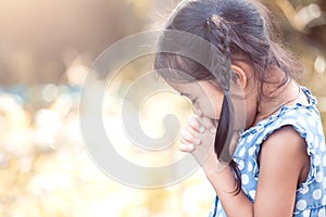 Cute asian little child girl praying with folded her hand