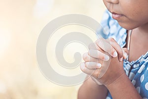 Cute asian little child girl praying with folded her hand