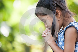 Cute asian little child girl praying with folded her hand